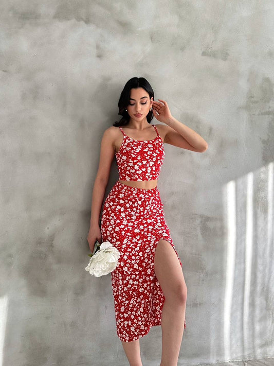 Kırmızı zemin üzerine beyaz çiçek desenli, askılı crop bluz ve yırtmaçlı etek ikili takım.