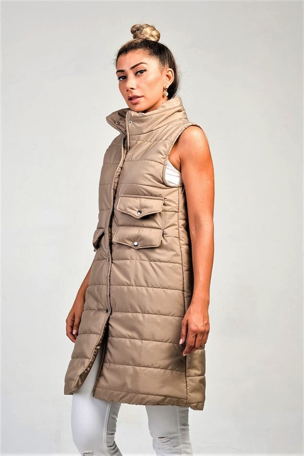 Bej renkli, dik yakalı, çıtçıtlı ve cepli uzun şişme yelek.