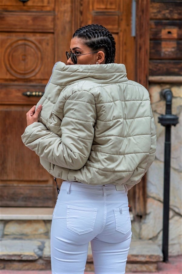 Bej renkli, dik yakalı, kısa ve su geçirmez şişme mont.