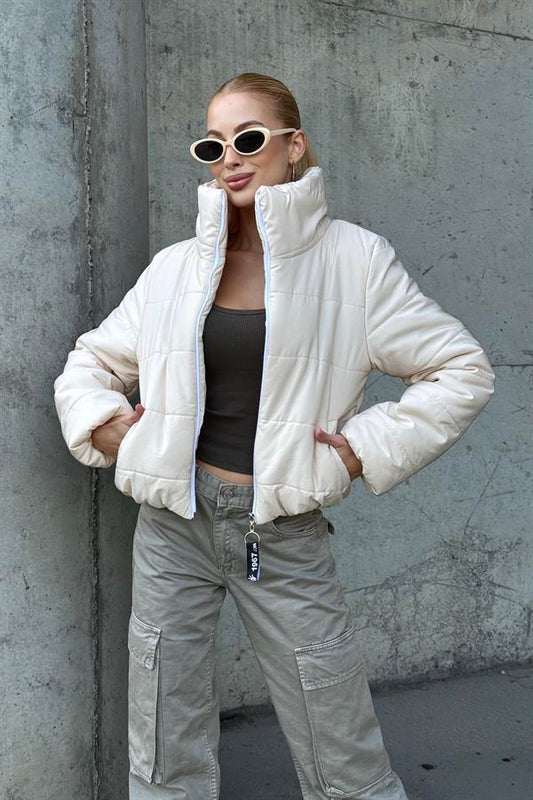 Bej renkli, dik yakalı ve kısa kesim şişme mont.