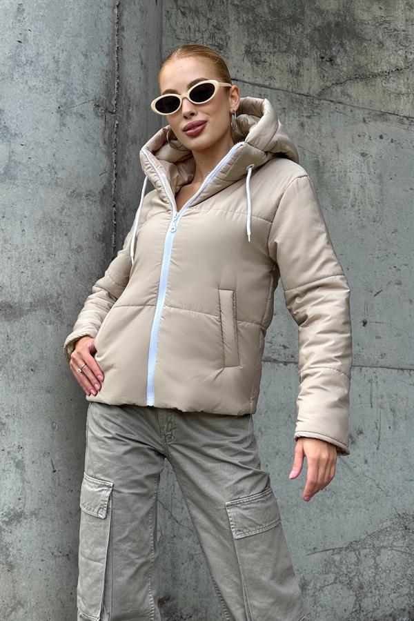 Bej renkli, kapüşonlu ve beyaz fermuarlı su geçirmez şişme mont.