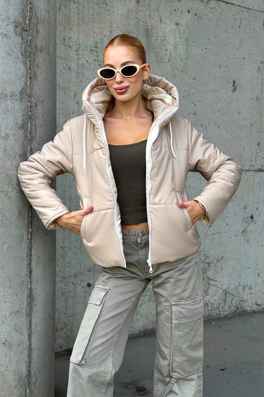 Bej renkli, su geçirmez, kapüşonlu ve astarlı şişme mont.