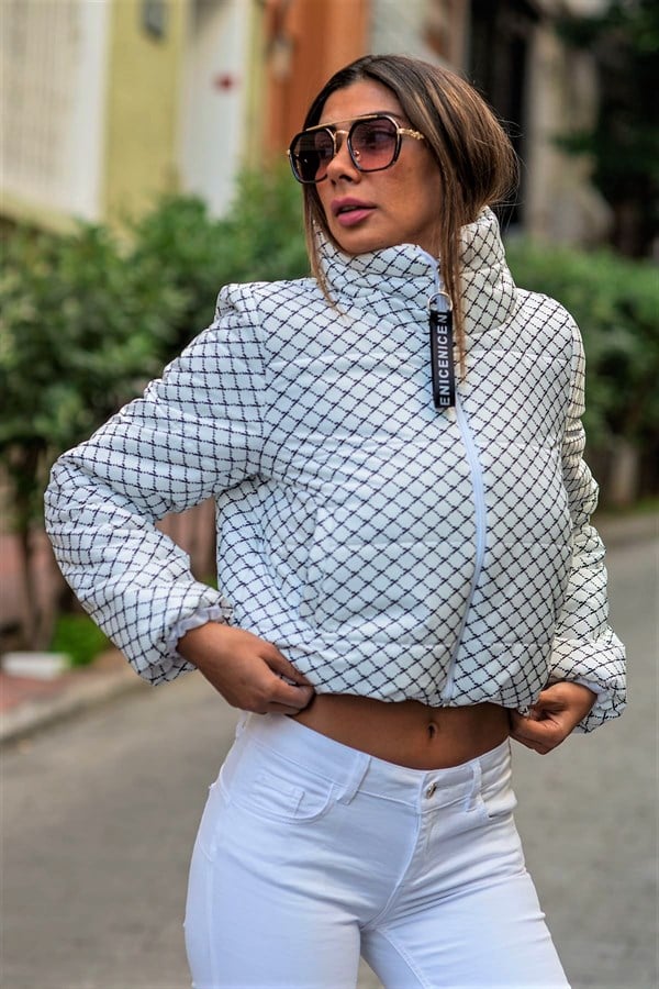 Beyaz renkli, dik yakalı, siyah desenli ve kısa kesim şişme mont.