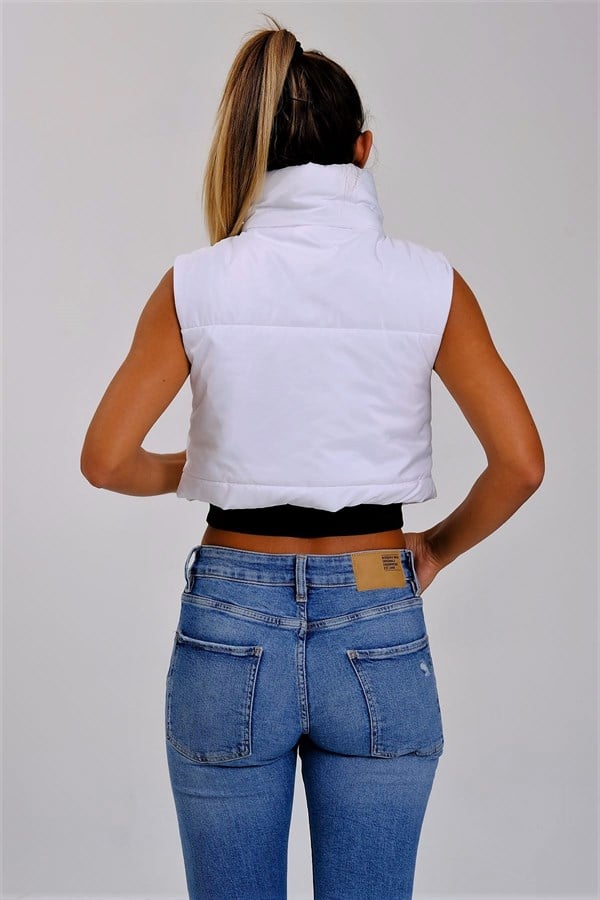 Beyaz renkli, dik yakalı ve kısa kesim şişme yelek.