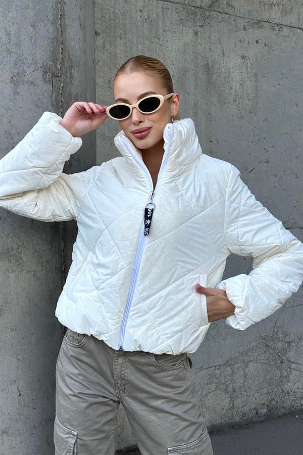 Beyaz, dik yakalı, şal desenli ve kısa kesim fermuarlı şişme mont.