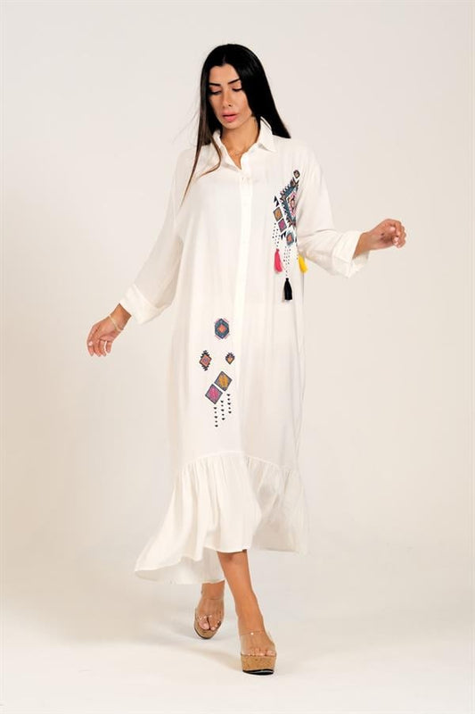 Beyaz, nakışlı ve püsküllü detaylara sahip, fırfırlı etekli uzun viskon gömlek elbise.