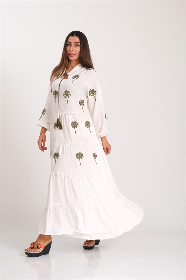 Beyaz renkli, palmiye nakışlı, püskül detaylı ve kat kat etekli uzun elbise.