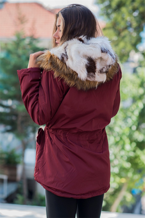 Bordo renkli, içi kürklü ve kürk detaylı kapüşona sahip su geçirmez kadın montu.