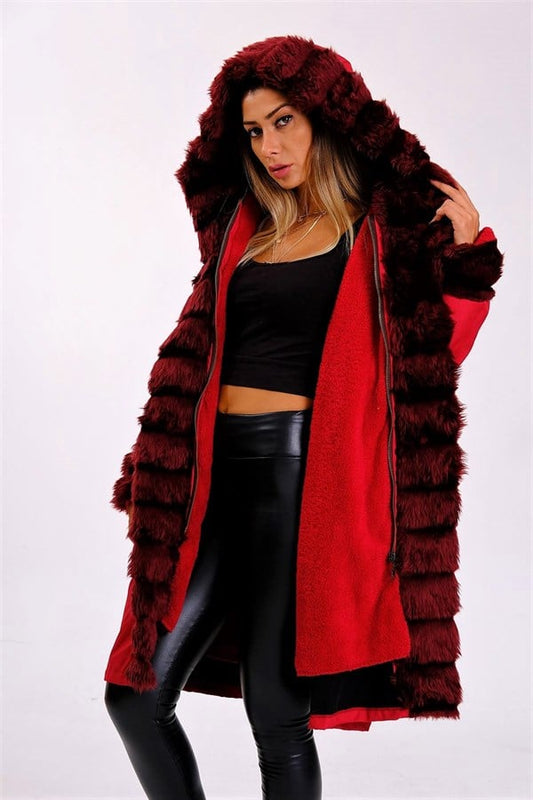 Bordo renkli, kapüşonlu, içi kürklü ve su geçirmez uzun kaban giyen bir kadın.