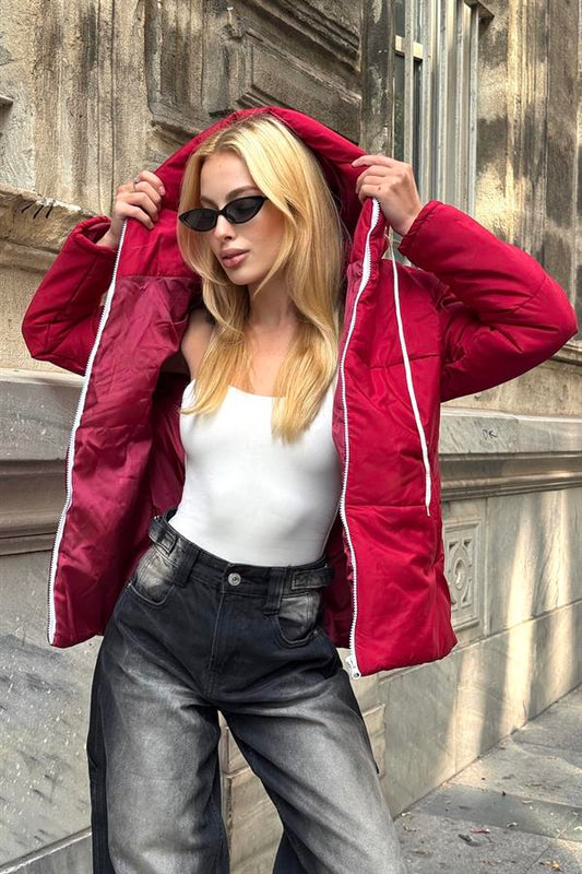 Bordo renkli, kapüşonlu ve beyaz fermuar detaylı su geçirmez şişme mont.