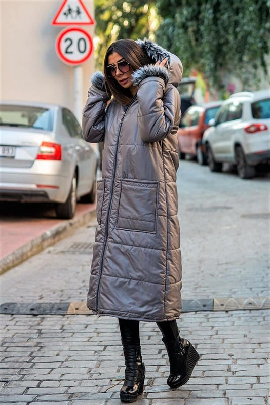 Gri renkli, kapüşonu ve kolları kürklü, fermuarlı, uzun şişme kaban.