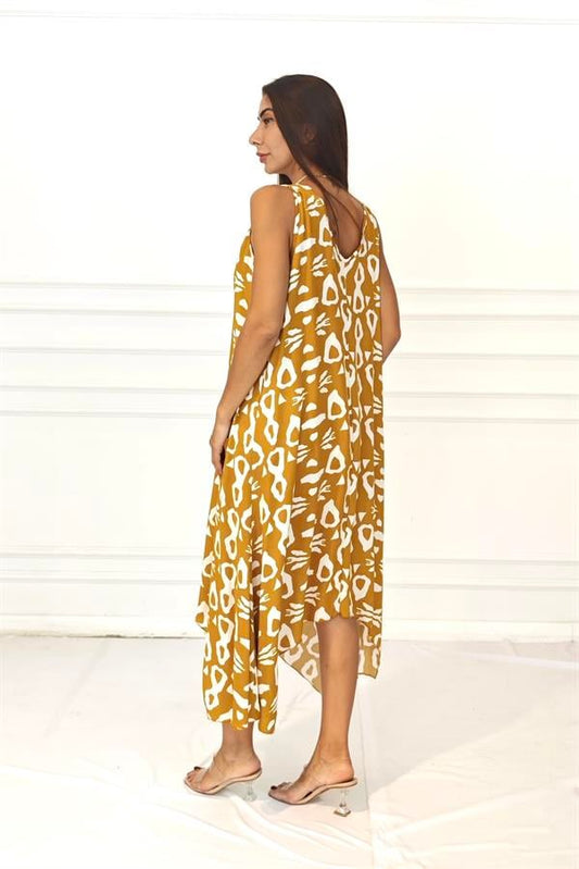 Hardal rengi, beyaz desenli, askısı halkalı ve asimetrik kesimli uzun viskon elbise.