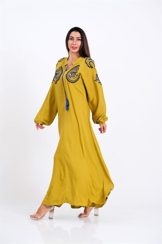 Hardal rengi, göğüs ve kol kısımları nakışlı, püskül detaylı, balon kollu uzun elbise.