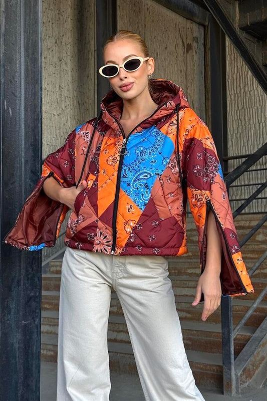 Kahverengi ve turuncu desenli, kapüşonlu, kolları fermuarlı kısa şişme mont.