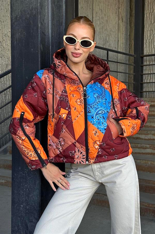 Kahverengi ve turuncu desenli, kapüşonlu, kolları fermuarlı kısa şişme mont.