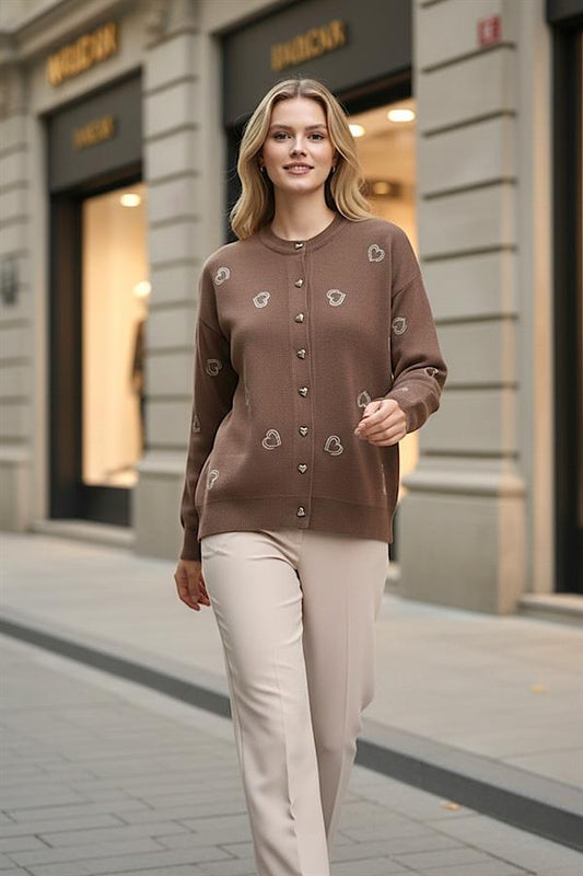 Kahverengi, kalp nakışlı ve düğmeli triko hırka giyen bir kadın.
