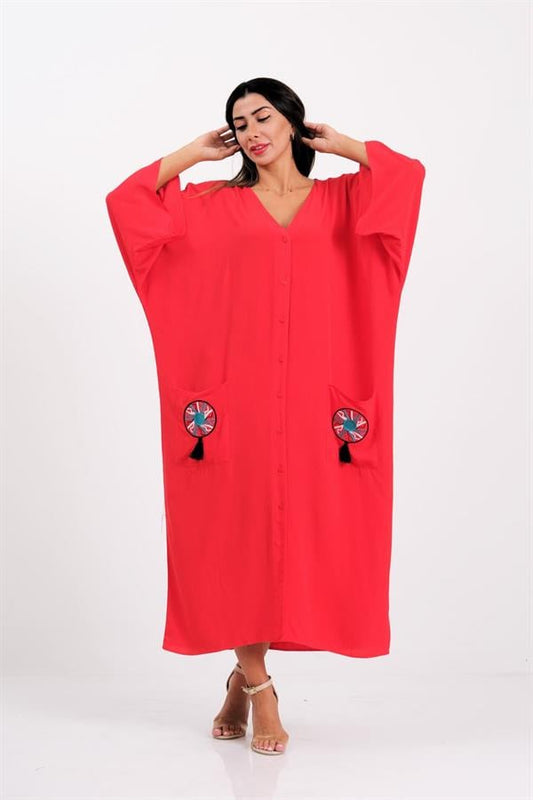 Kırmızı renkli, V yaka, önü düğmeli, cepleri nakışlı ve püsküllü oversize uzun elbise.
