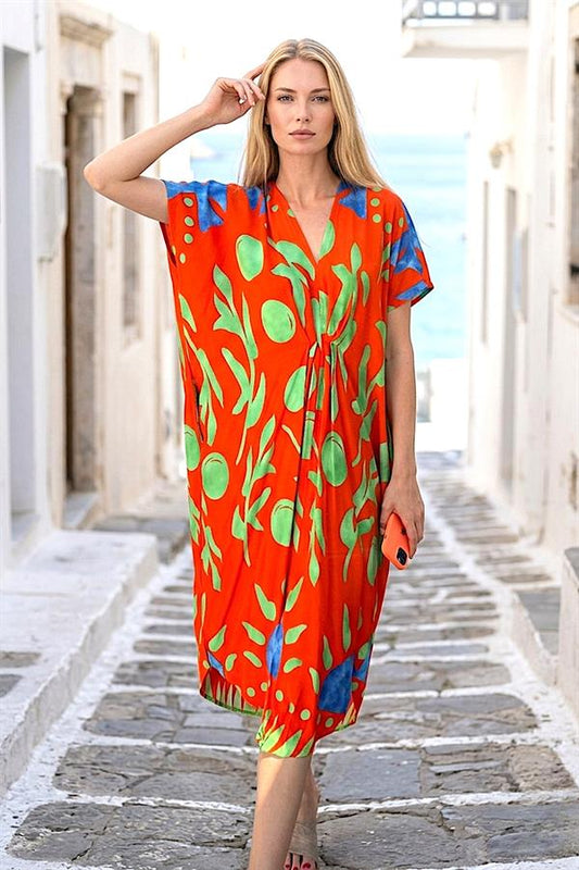 Kırmızı zemin üzerine yeşil desenli, V yaka, cepli ve viskon kumaşlı midi boy elbise.