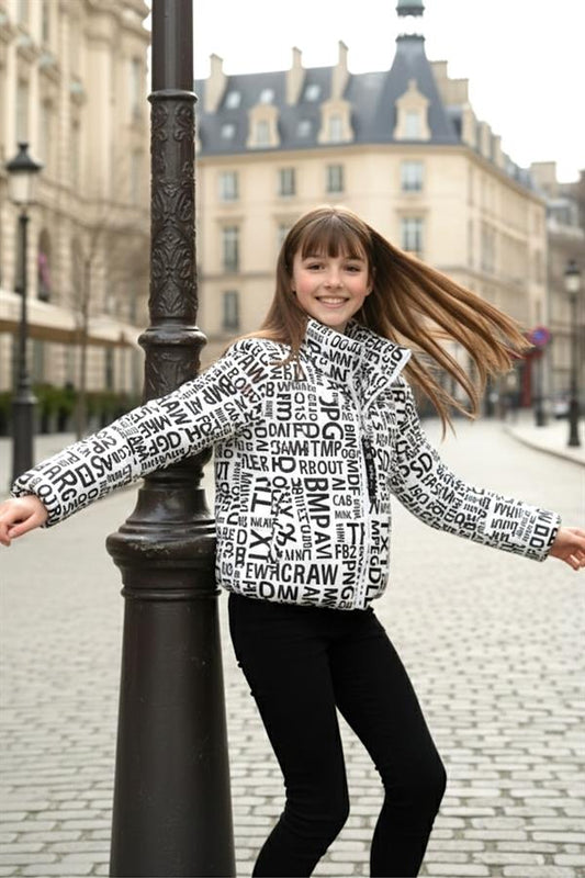 Siyah harf desenli, dik yakalı ve astarlı beyaz şişme kız çocuk montu.