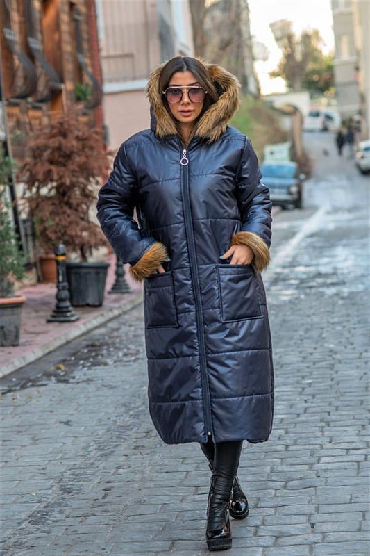 Lacivert renkli, kapüşonu ve kolları kürklü, fermuarlı, uzun şişme kadın kabanı.