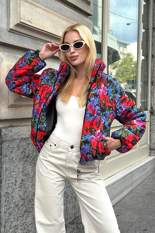 Dik yakalı, çiçek desenli, kısa ve şişme kadın montu.