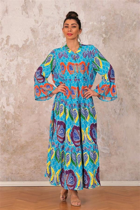 Mavi renkli, tropikal desenli, volanlı kollu ve kat kat etekli uzun viskon elbise.