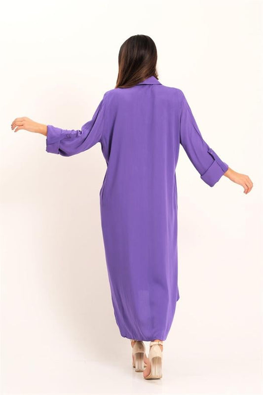 A woman wears a long-sleeved purple shirt dress with epaulets and a high-low hem.