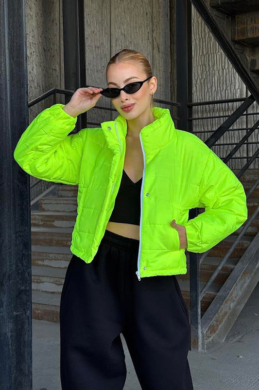Neon yeşil renkli, dik yakalı, fermuarlı ve çıtçıtlı kısa şişme mont.