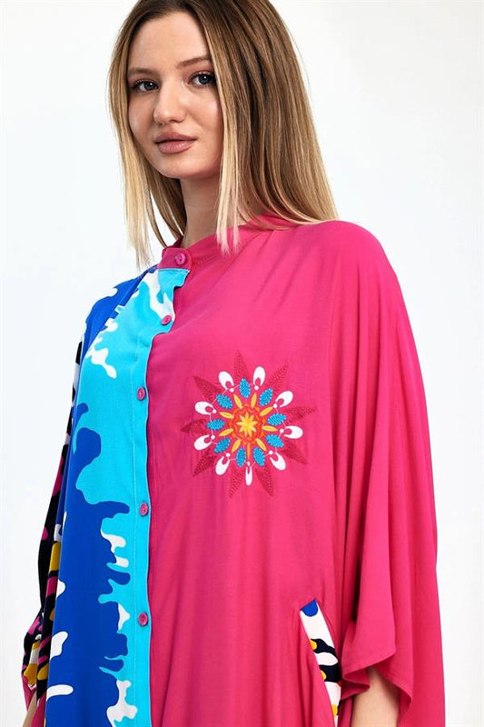 Pembe renkli, göğsü nakışlı, desenli garnili ve düğmeli oversize uzun elbise.