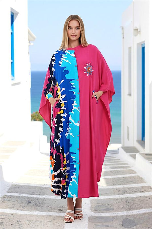 Pembe renkli, önü düğmeli, desenli garnili ve göğsü nakışlı oversize uzun elbise.