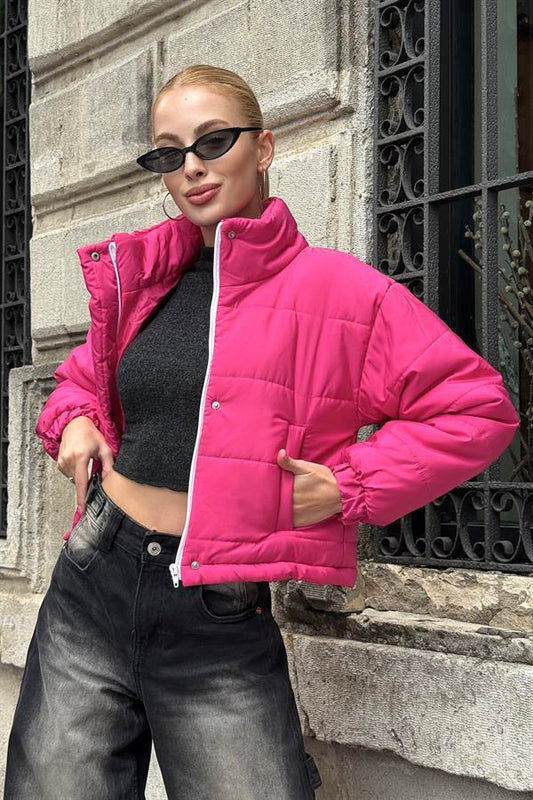 Dik yakalı, fermuarlı ve çıtçıtlı, pembe renkli kısa şişme mont.
