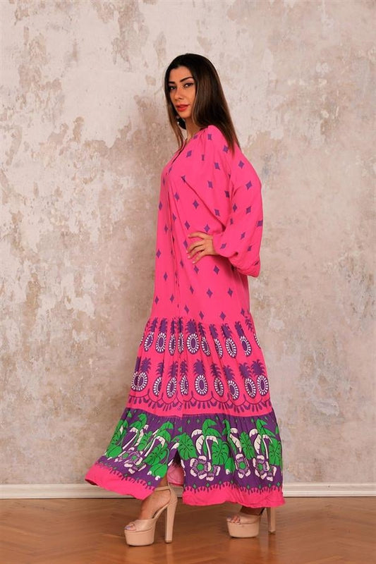 Pembe renkli, balon kollu, önü düğmeli ve etek ucu desenli uzun viskon elbise.