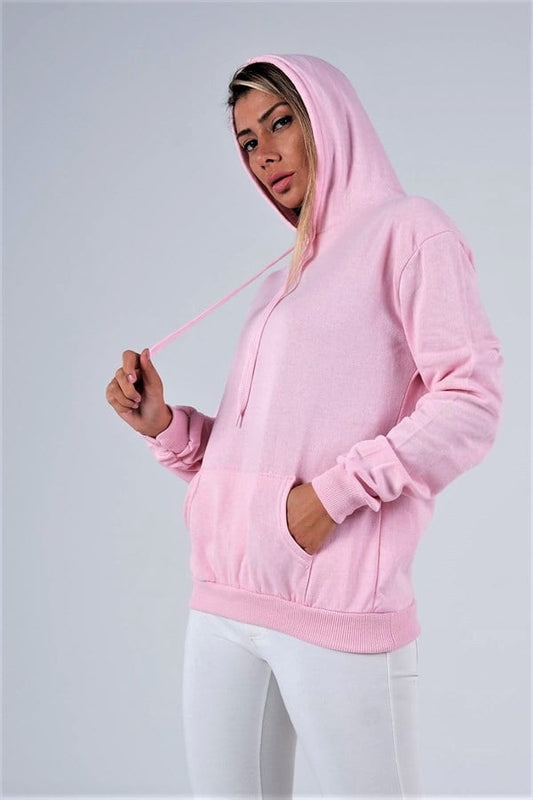 Pembe renkli, kapüşonlu, kanguru cepli ve şardonlu sweatshirt giyen bir kadın.