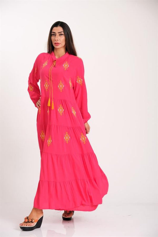 Pembe renkli, önü ve kolları otantik nakışlı, püskül bağcıklı ve kat kat etekli uzun elbise.