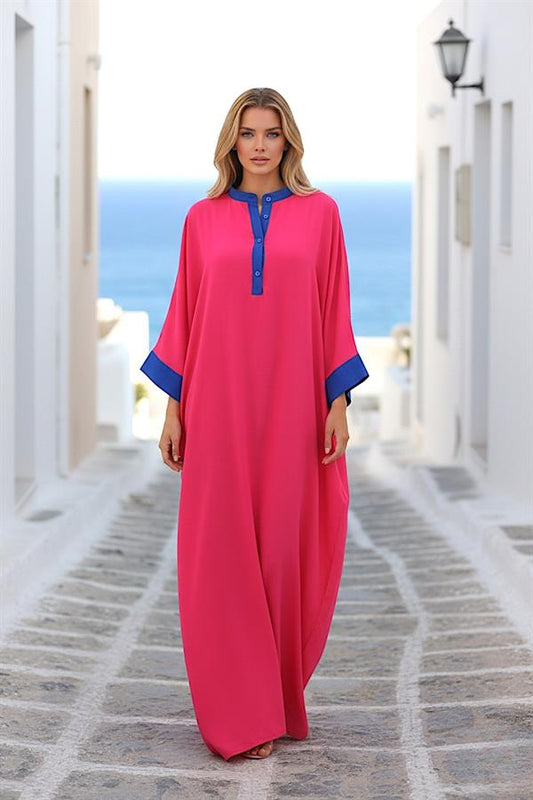Mavi detaylı, önden düğmeli, pembe renkli, yarasa kollu ve uzun oversize elbise.