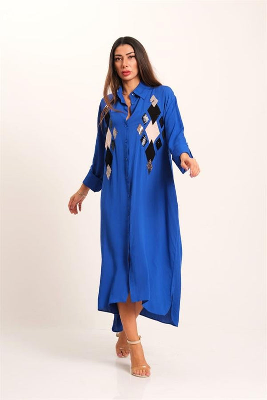 A model wears a long, royal blue button-down shirt dress featuring sequined diamond-shaped patterns.