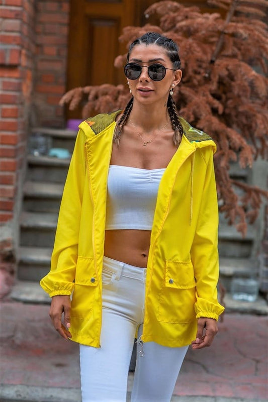 Sarı renkli, kapüşonlu, fermuarlı ve cepli ince kadın yağmurluk.