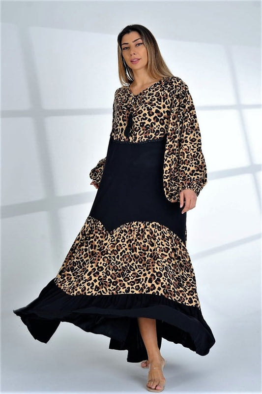 A woman wears a long, oversized dress featuring a black bodice and leopard print panels with balloon sleeves.