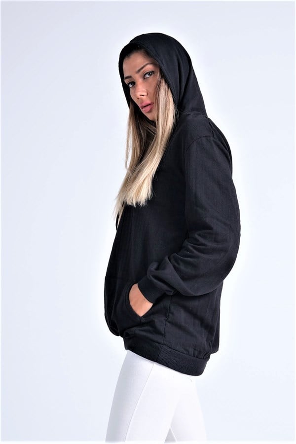 Siyah renkli, kapüşonlu, kanguru cepli ve şardonlu sweatshirt giyen bir kadın.