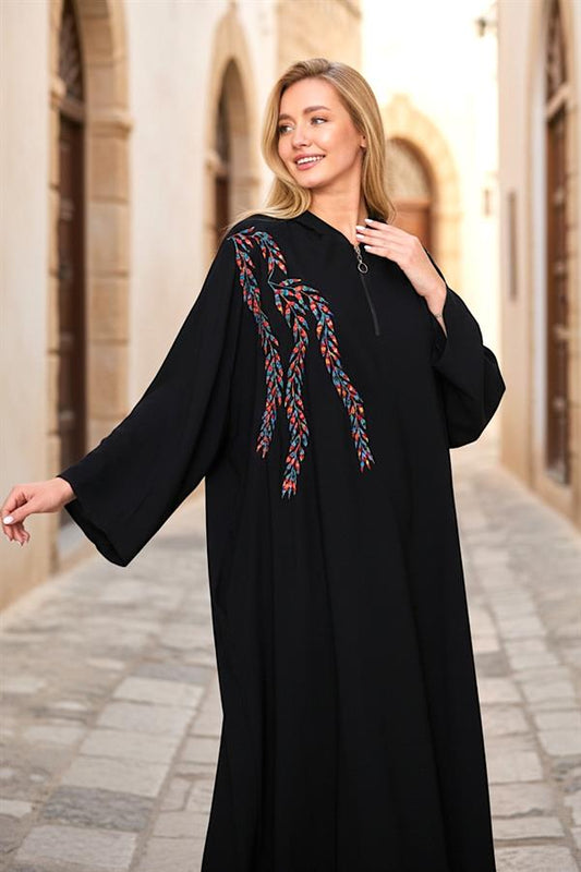 Siyah renkli, fermuarlı, kapüşonlu ve göğüs kısmında renkli nakış detayları bulunan uzun elbise.