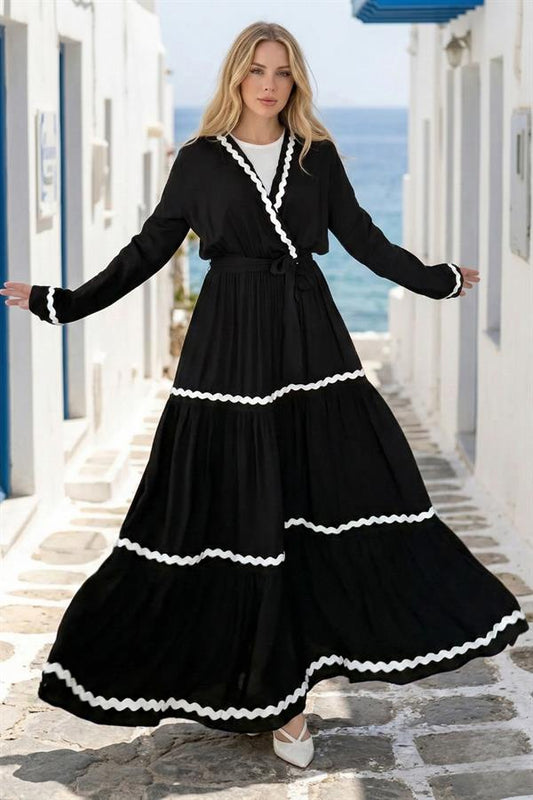 Beyaz zikzak detaylı, kuşaklı, siyah kruvaze yaka kat kat uzun viskon elbise.