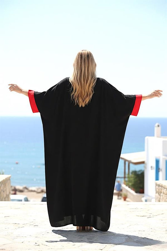 Kırmızı manşetli, siyah, uzun, yarasa kollu ve oversize viskon elbise.