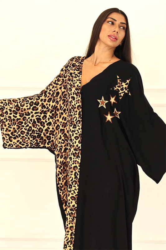 Siyah renkli, leopar desenli detaylara ve yıldız aplikeli nakışlara sahip oversize uzun elbise.