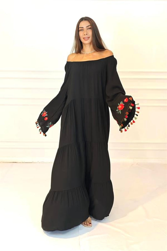 Siyah, madonna yakalı, kolları çiçek nakışlı ve püsküllü, kat kat uzun viskon elbise.