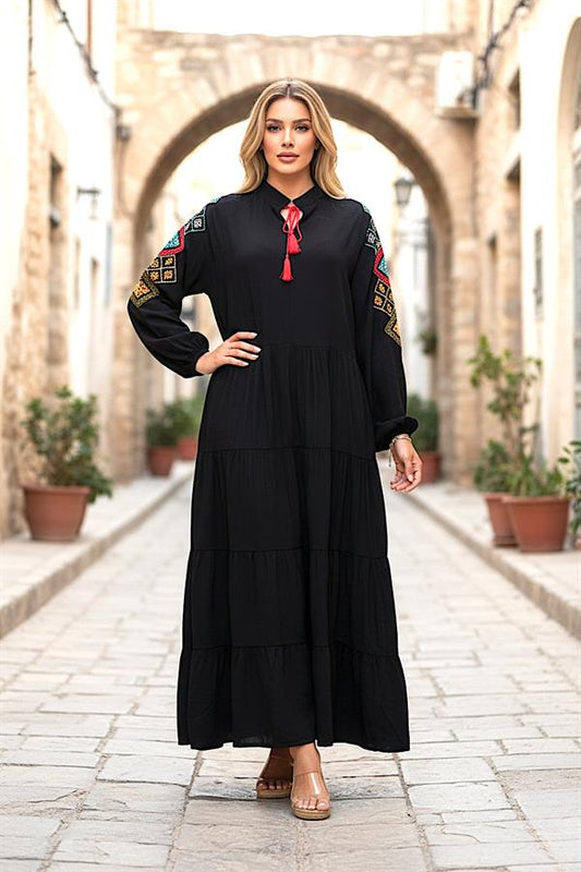 Siyah, sıfır yaka, kolları nakışlı ve etek kısmı kat kat olan uzun viskon elbise.