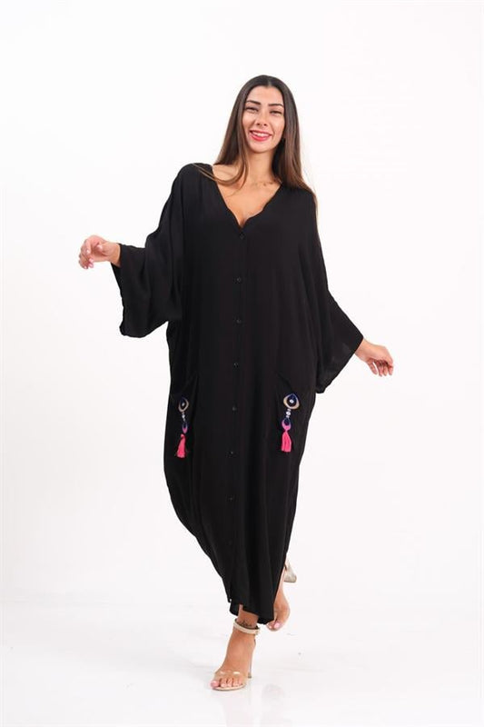 Siyah, V yaka, düğmeli, ceplerinde otantik nakış ve püskül detayları bulunan oversize uzun elbise.