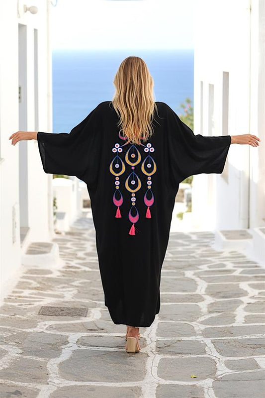 Sırtında renkli otantik nakışlar ve püsküller bulunan, siyah, oversize uzun gömlek elbise.