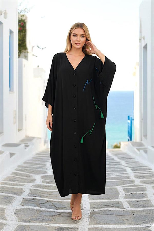 Siyah V yaka, önü düğmeli, yanlarında renkli nakış ve püskül detayları bulunan uzun gömlek elbise.
