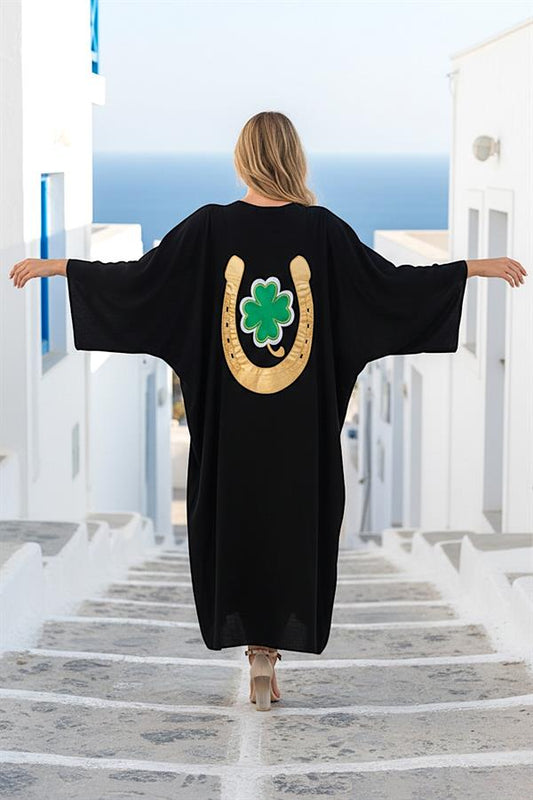 Sırtında altın rengi nal ve yeşil yonca nakışı bulunan siyah oversize uzun gömlek elbise.