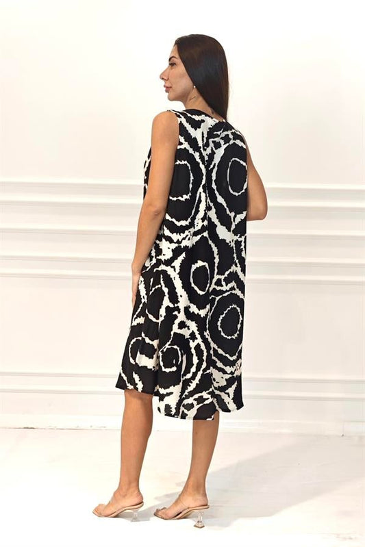 Siyah zemin üzerine beyaz yuvarlak desenli, kalın askılı, viskon kumaşlı midi elbise.